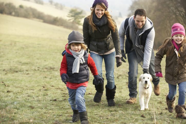 Family walking dog in the countryside