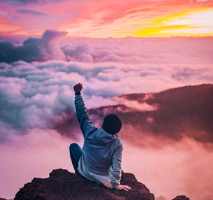 Man on the top of a mountain elated