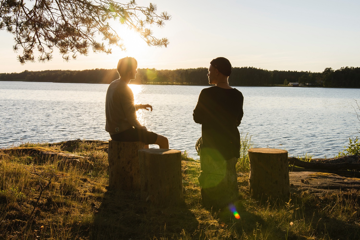 Two men talking next to a lake