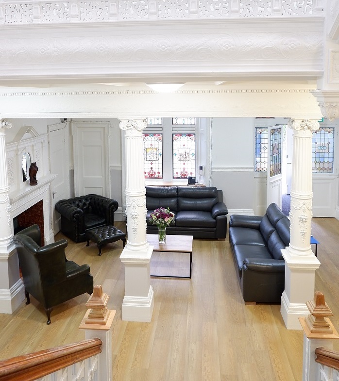 Lobby area with stained glass, ornate pillars and sofas