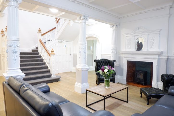 Entrance hall with fireplace, seating and staircase