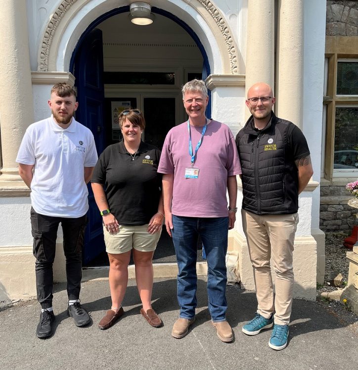 Three Switch Health employees outside of Broadway Lodge with our CEO, John